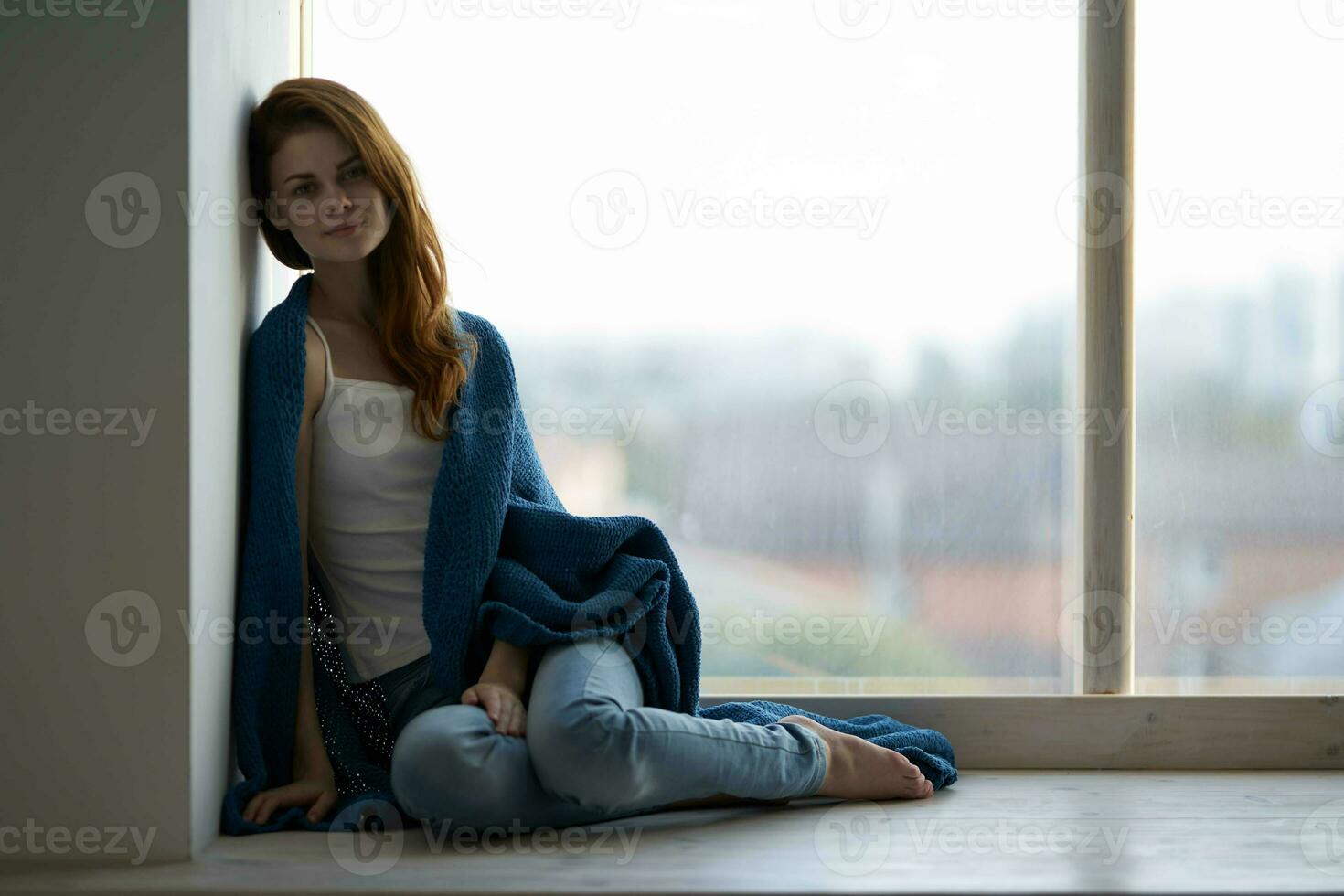 pretty woman sitting near the window with a blue plaid photo