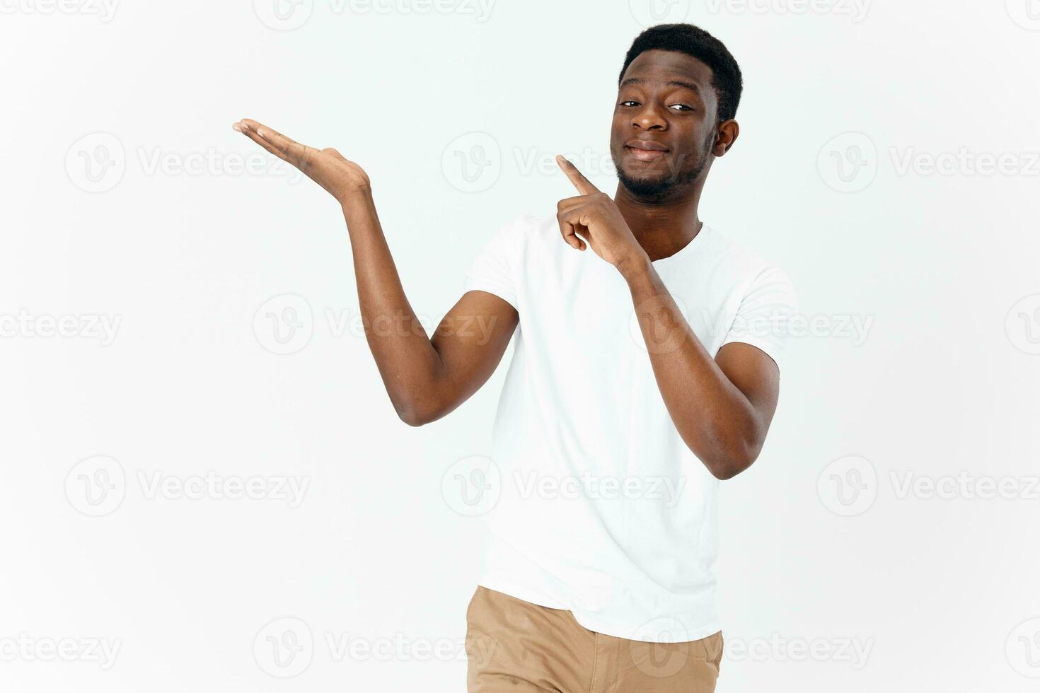 cute african man in white t-shirt gesturing with hands on light background cropped view photo