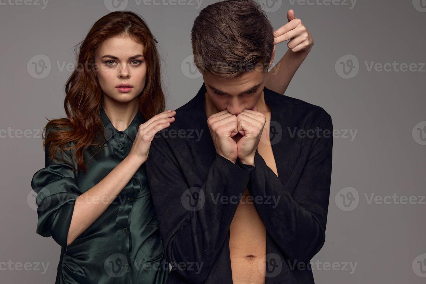 An upset man holds his hands near his face and a woman in a dress calms him down photo