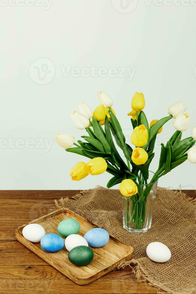 vistoso huevos en un bandeja amarillo flores fiesta Pascua de Resurrección foto