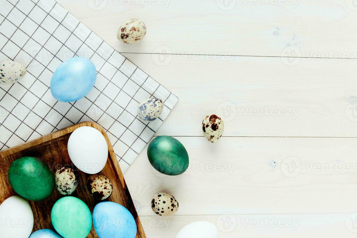 Easter holiday colorful eggs on a wooden table checkered fabric top view photo