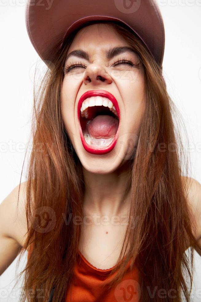 Beautiful woman in a cap Face close-up wide open mouth red lips photo