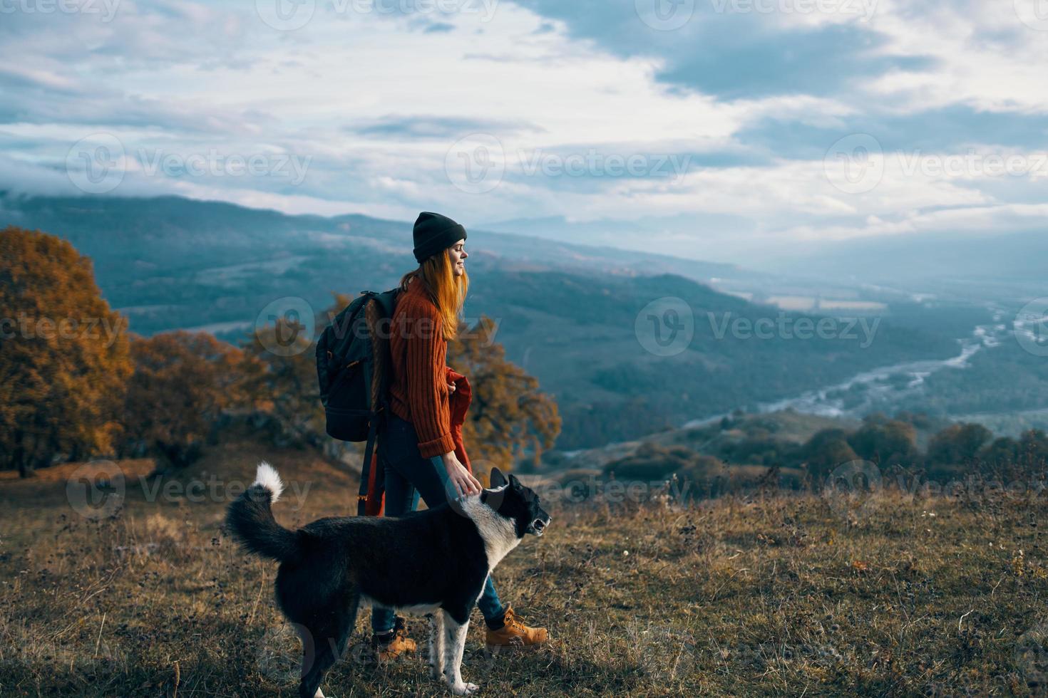 woman with backpack on nature next to dog walk mountain landscape photo