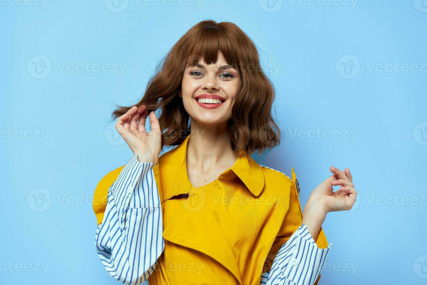 portrait of woman in yellow coat with blue striped lines laughing emotions photo