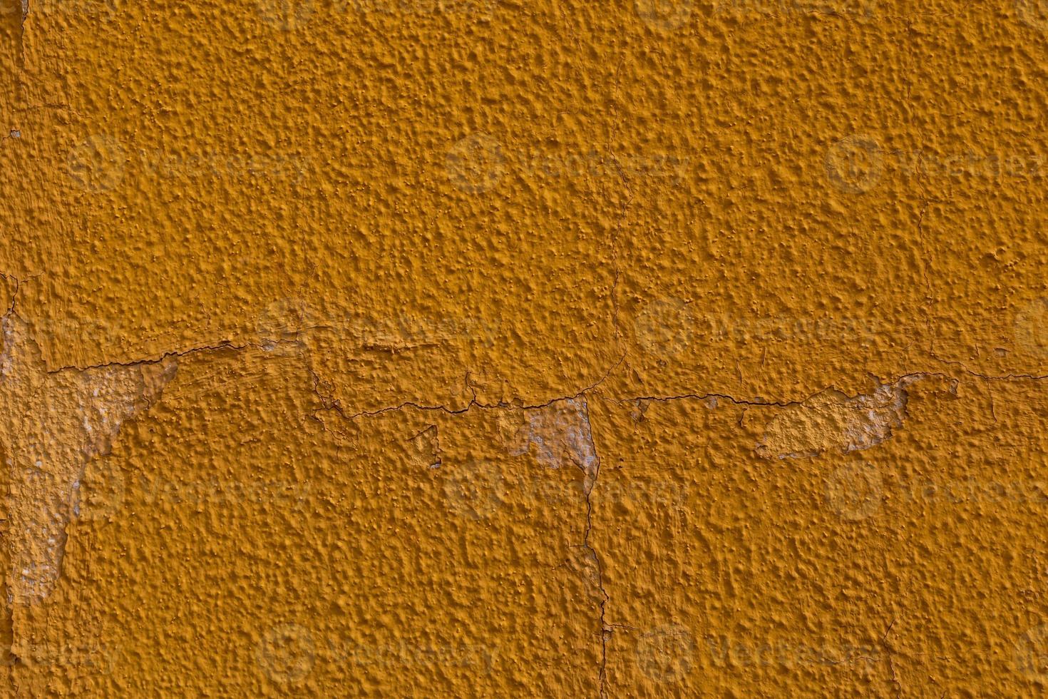 background of old colorful wall with cracked plaster in close-up photo