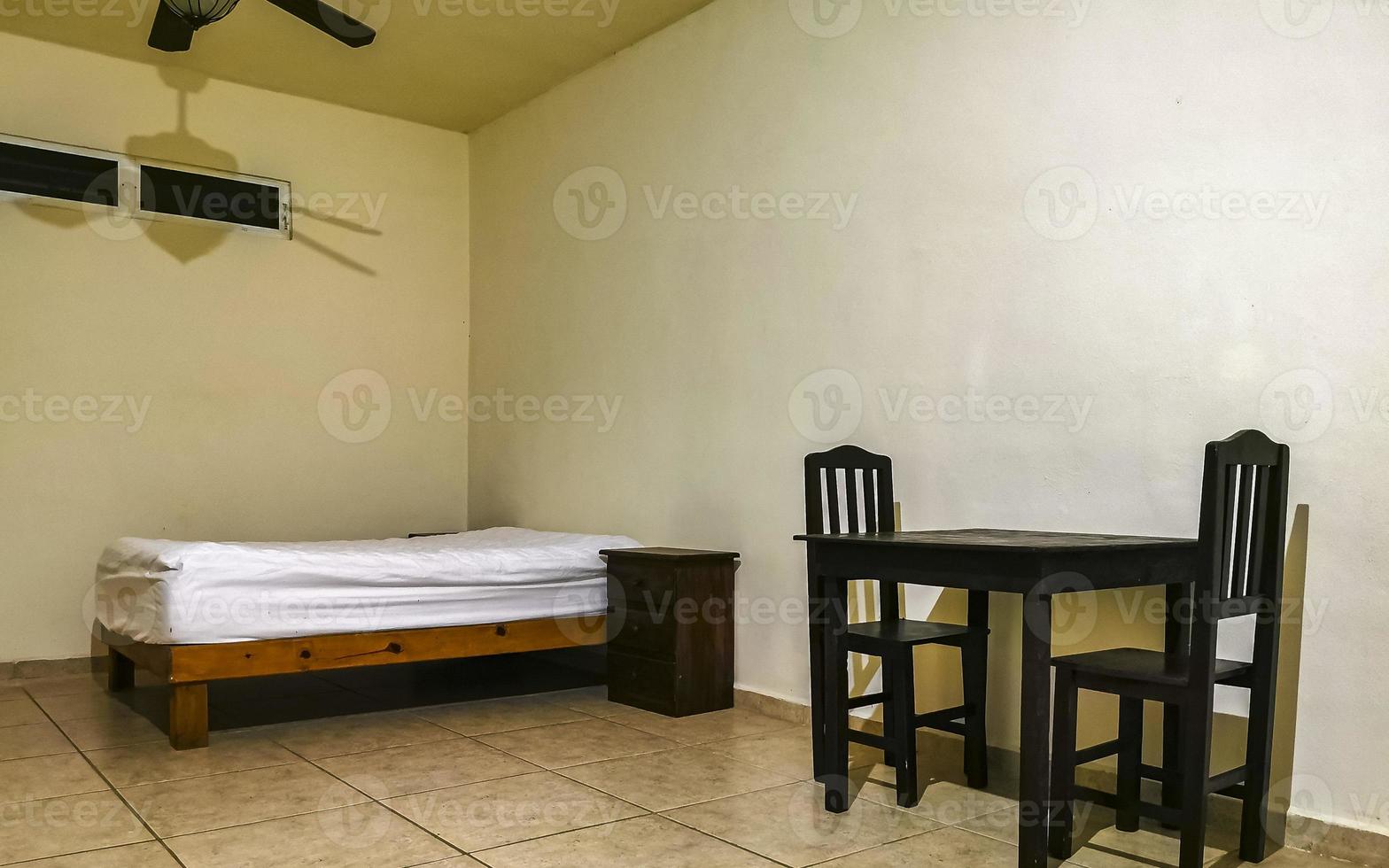 Simple small apartment hotel room with bed table in Mexico. photo