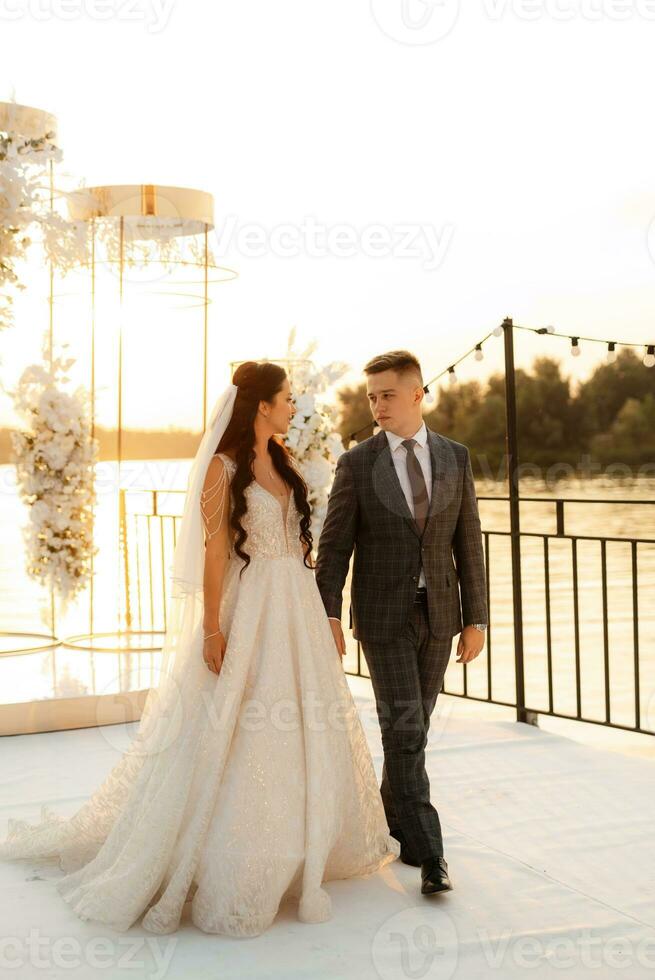 bride and groom against the backdrop of a yellow sunset photo