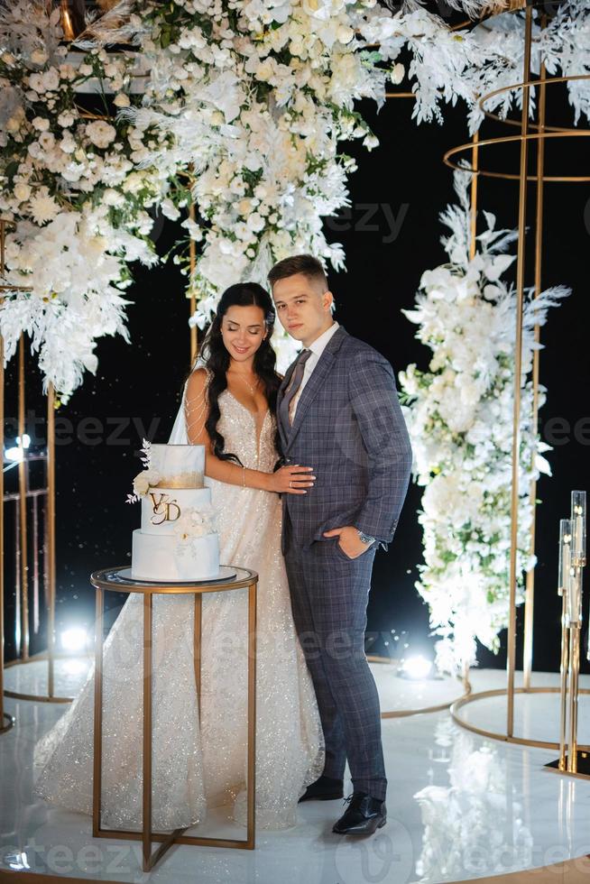 newlyweds happily cut and taste the wedding cake photo