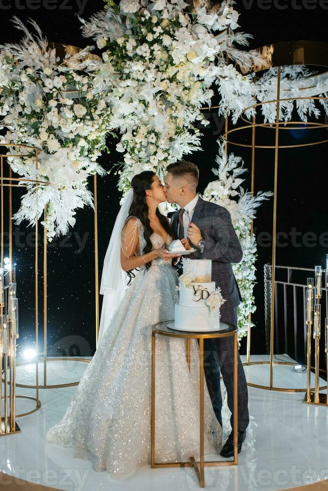 newlyweds happily cut and taste the wedding cake photo
