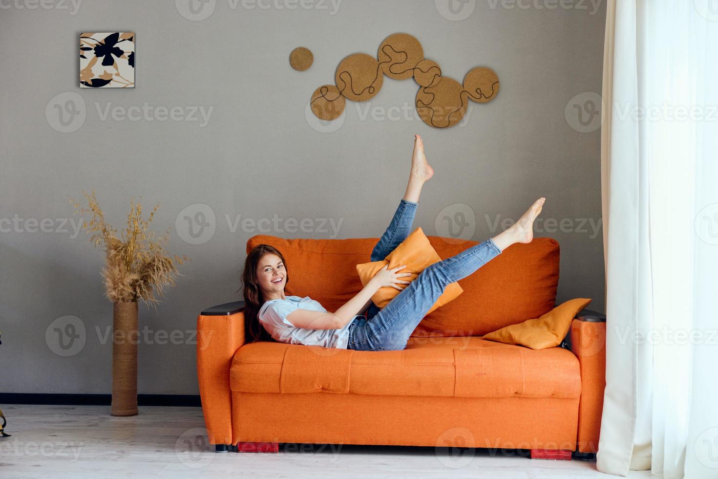 beautiful woman on the orange couch in the rest room posing Lifestyle photo