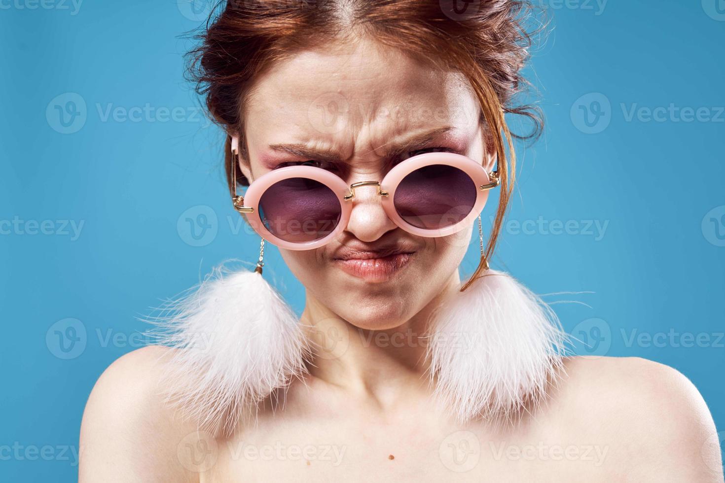 emotional woman wearing sunglasses fluffy earrings face close up photo