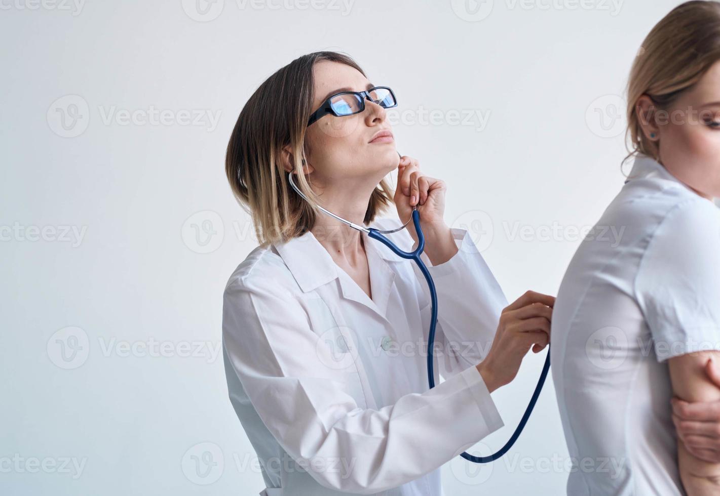 profesional médico mujer con estetoscopio y hembra paciente lado ver foto