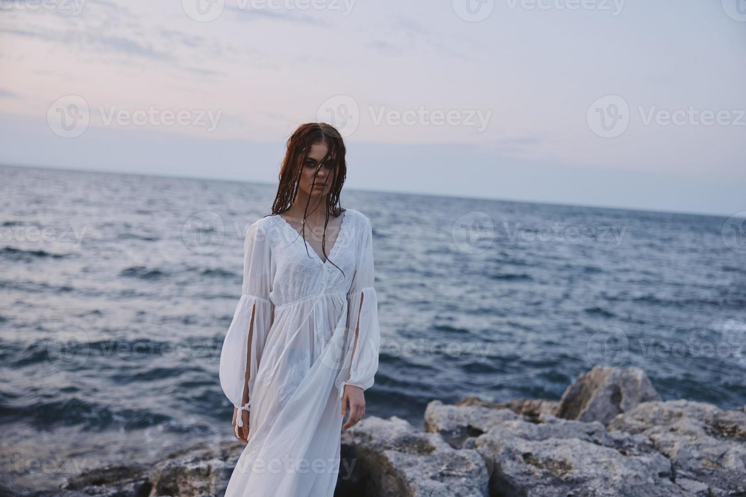 atractivo mujer disfrutando para ver de el hermosa mar en su fiesta naturaleza inalterado foto