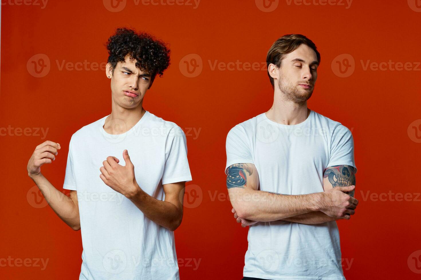 Two men in white t-shirts stand next to communication red background photo
