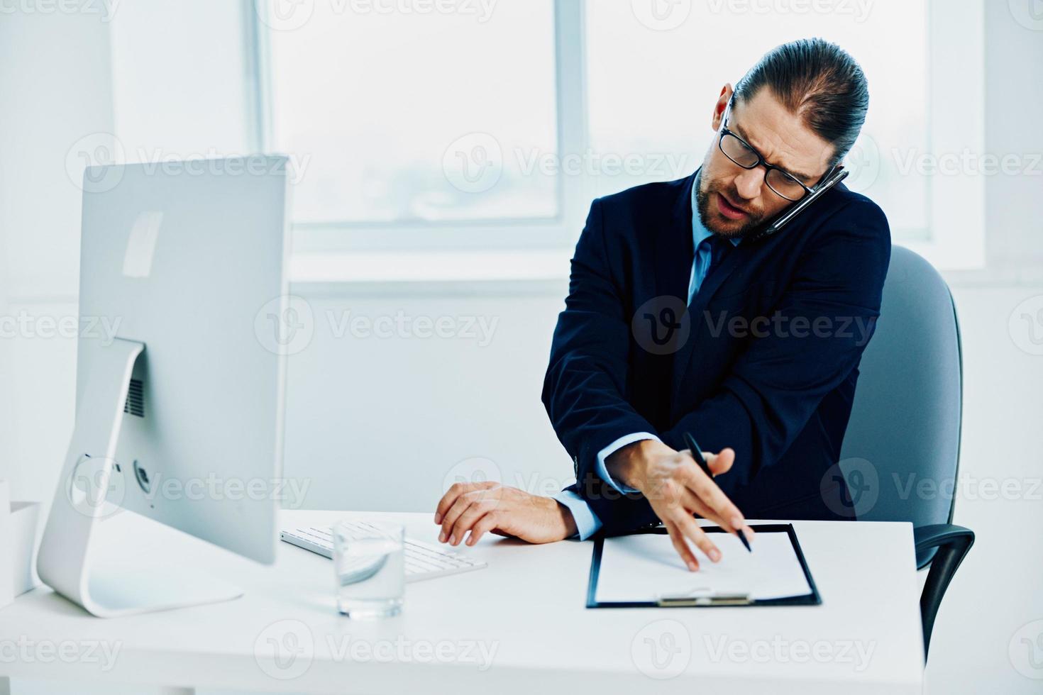 The man in a suit in the office gestures with his hands computer photo