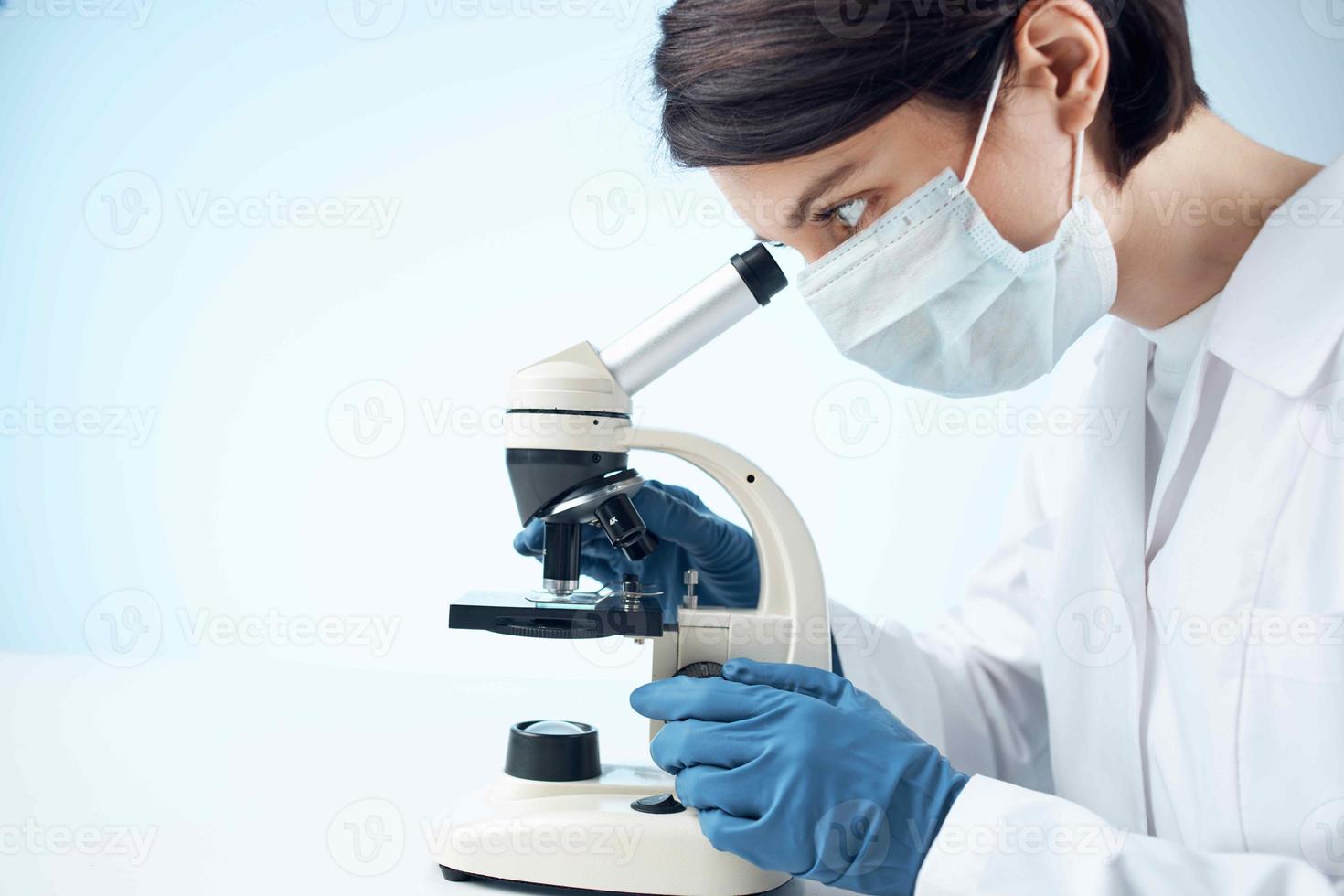 female doctor in medical mask microscope technology research photo