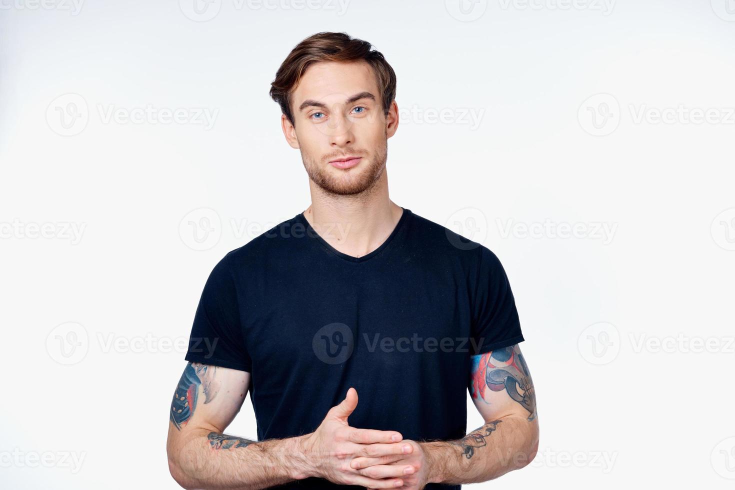 portrait of a man in a blue t-shirt with a tattoo on his arm blonde hair gray background photo