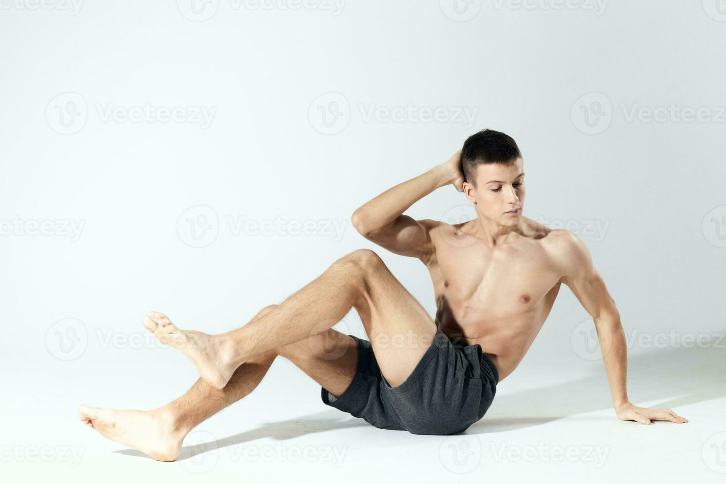 morning exercises young athlete in gray shorts and an inflated torso fitness photo