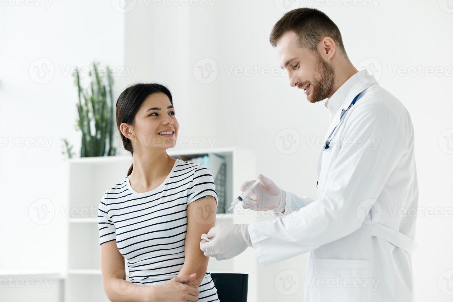 masculino médico dando un inyección a un mujer vacunación salud foto