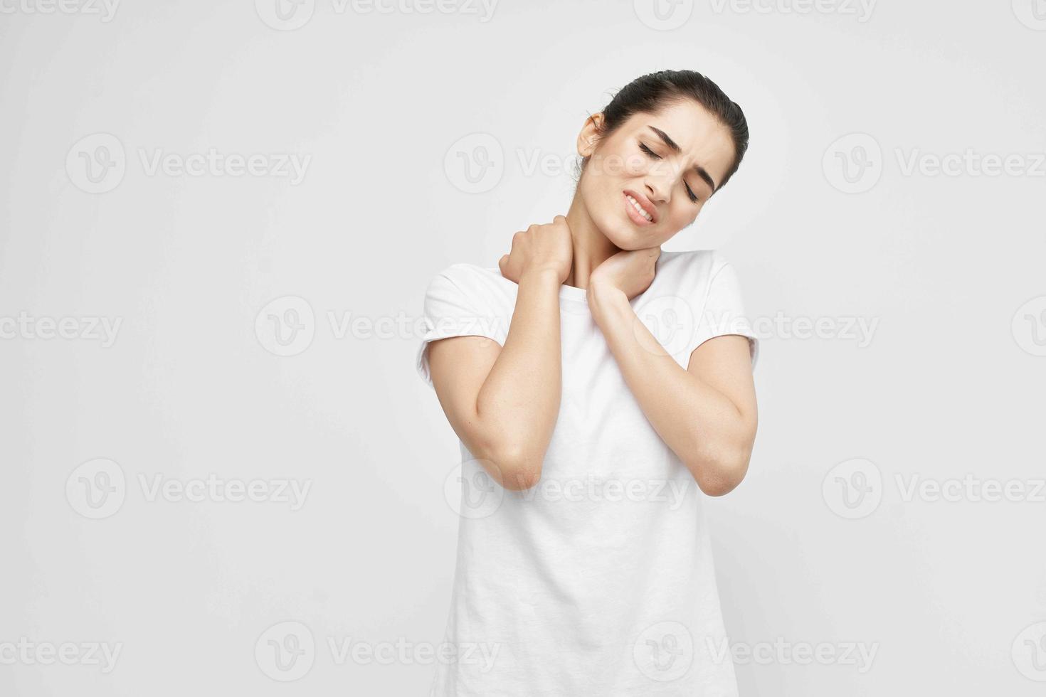 morena en un blanco camiseta dolor en el cuello salud problemas foto