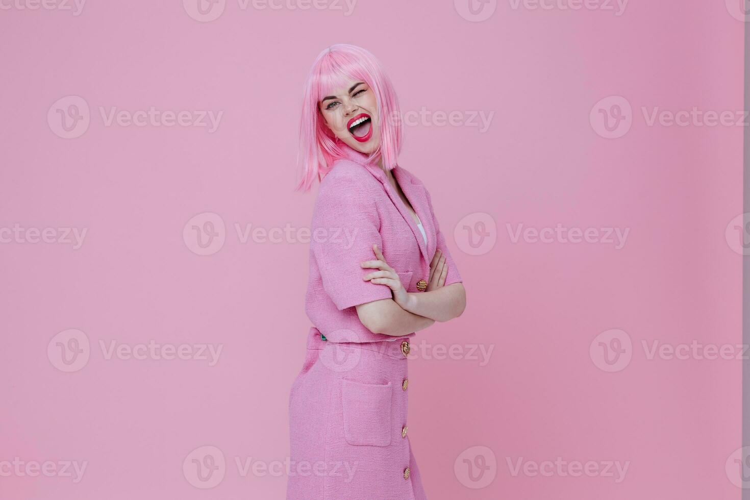 retrato de un encantador dama en un rosado traje gesticulando con su manos emociones divertido rosado antecedentes inalterado foto