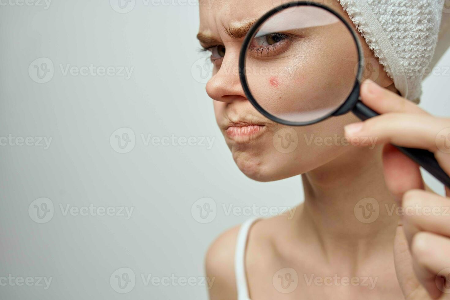 pretty woman with a magnifying glass in hand skin problems close-up photo