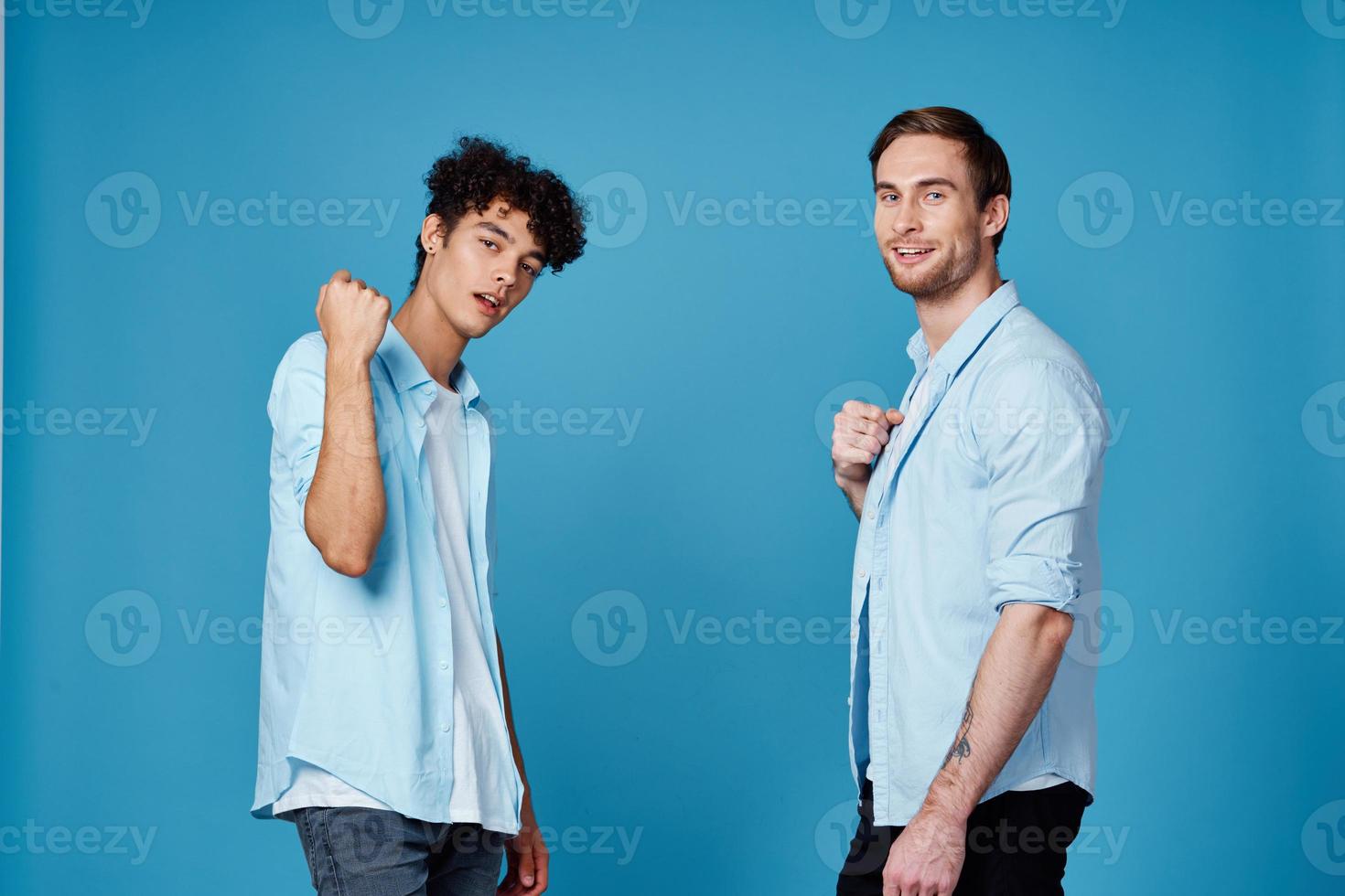 curly-haired guy in a shirt greets his friend on a blue background photo