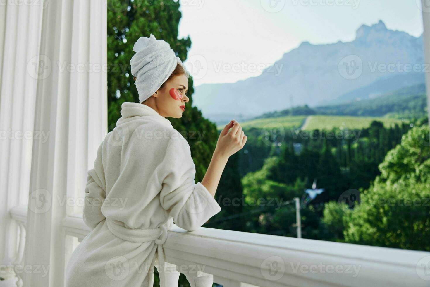 Woman in a bathrobe with patches on his face admires nature Lifestyle photo