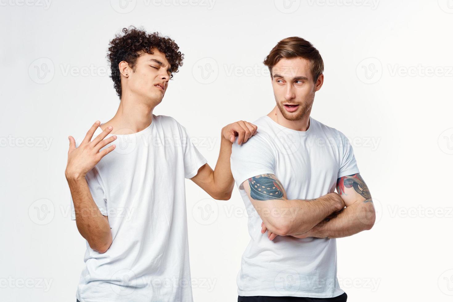 two men in white t-shirts are standing side by side isolated background photo