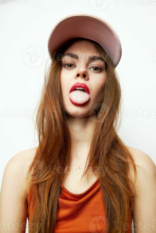 emocional mujer en un gorra palos fuera lengua encanto modelo sexy Mira foto