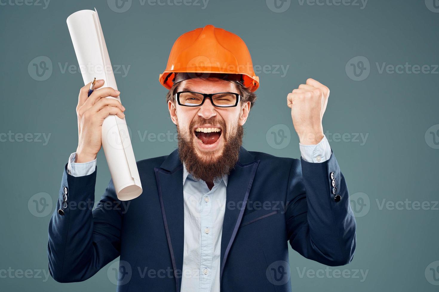 Cheerful man with blueprints in hands in orange helmet safety engineer cropped view photo