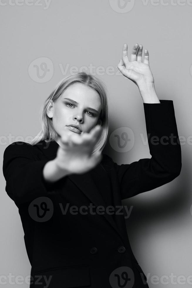 A young incredible blonde pulls her hands into the camera posing in the studio. Art fashion photography photo