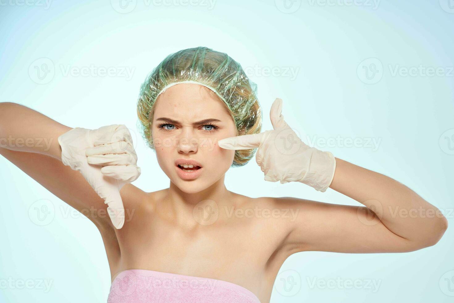 woman squeezes out black dots on her face gloves bare shoulders photo