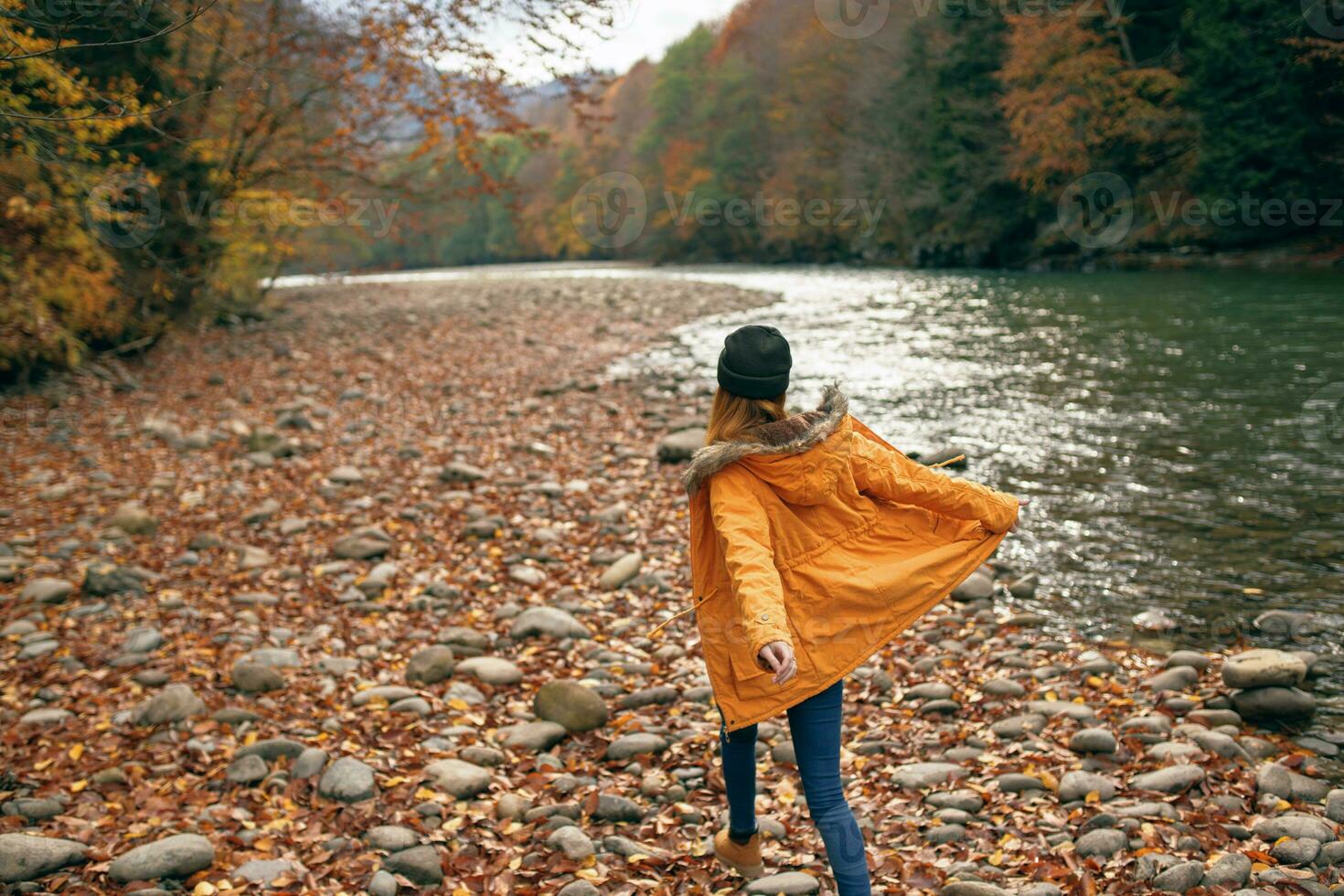 mujer caminando en el bosque a lo largo el río otoño viaje foto