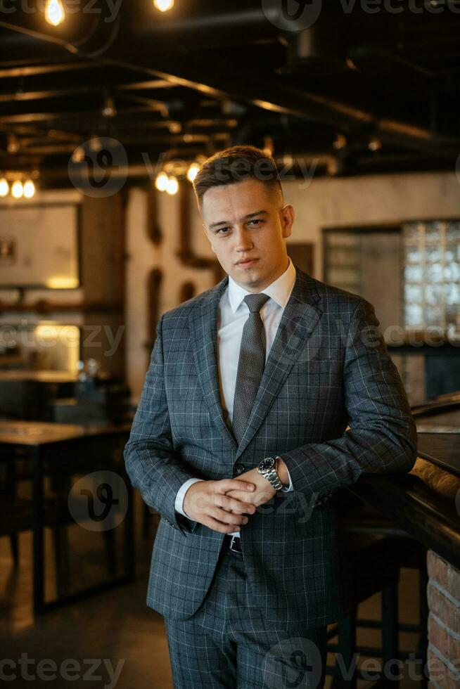 portrait of a groom in a gray plaid suit with a tie photo