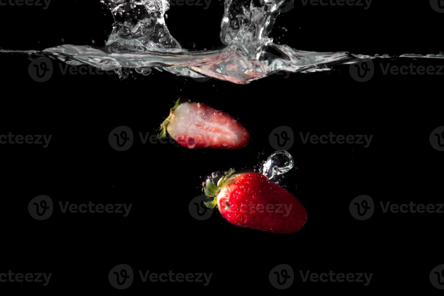 Fresco fresas con agua chapoteo foto