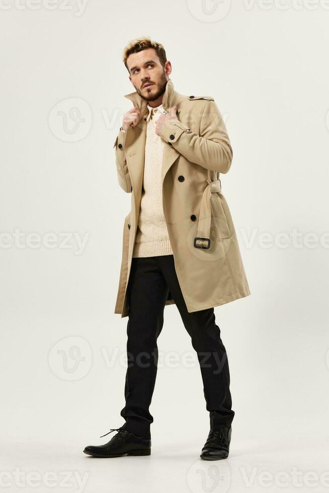 handsome man in beige coat fashion modern style side view full length photo