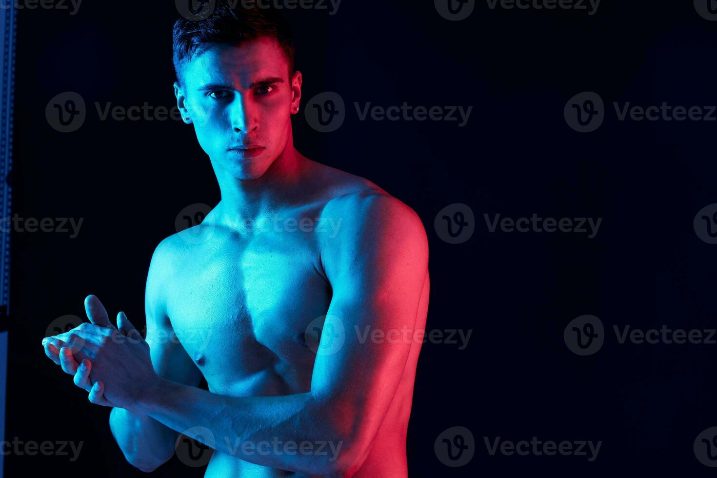 portrait of a young man with a pumped-up torso on a black background close-up photo