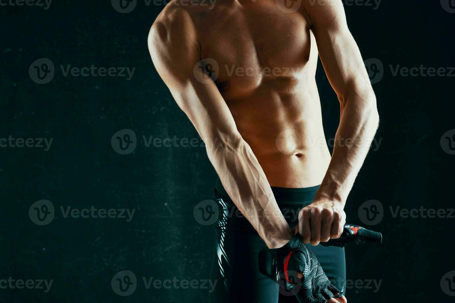 athletic men with a pumped-up body workout posing dark background photo