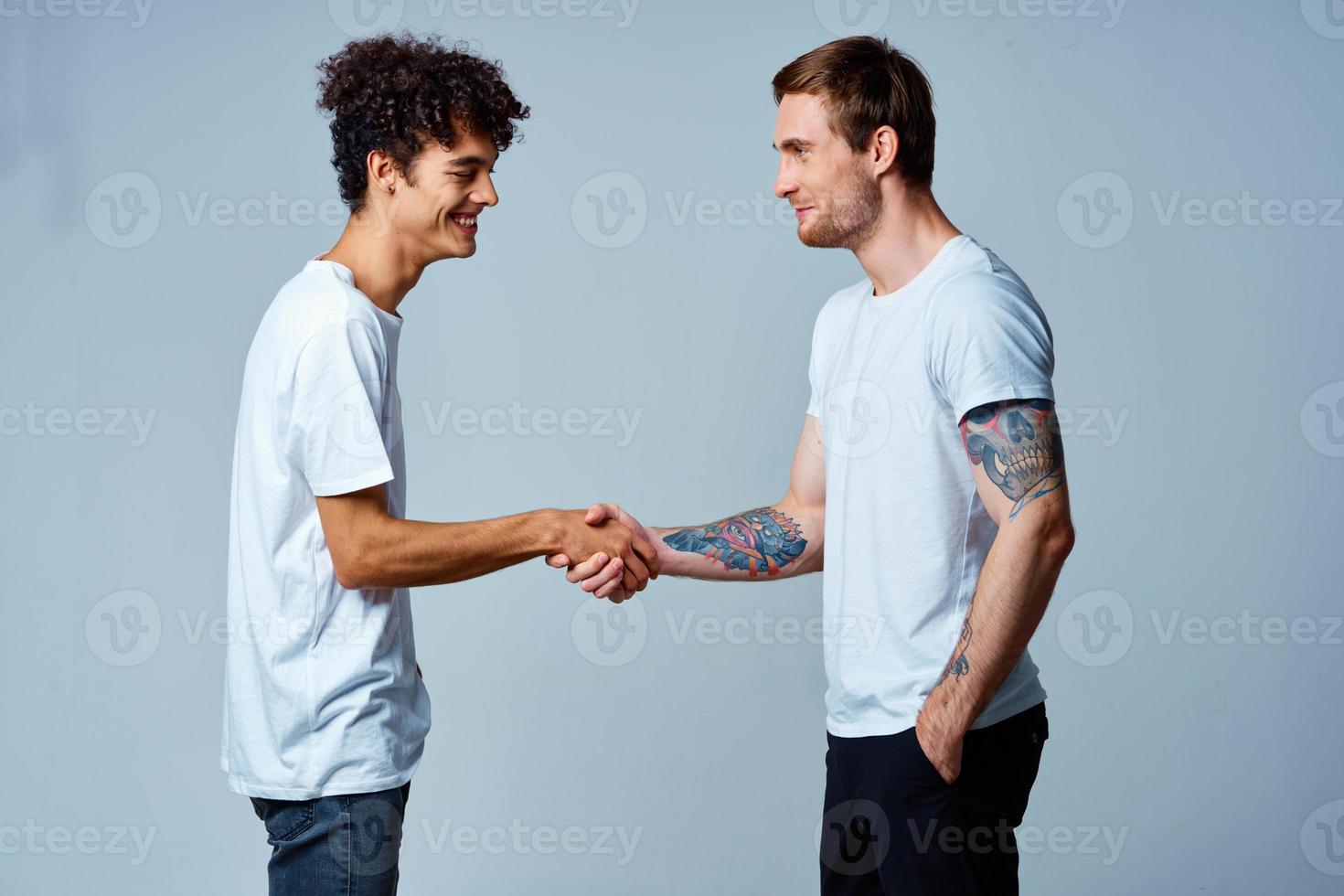 two friends hold hands in white t-shirts isolated background photo