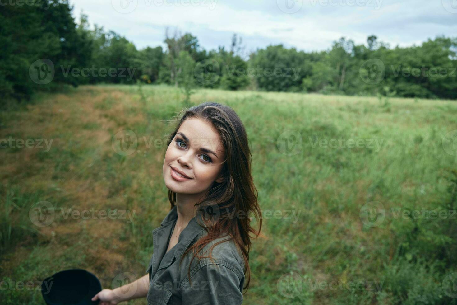 Woman portrait green overalls looking forward against the background of the field photo