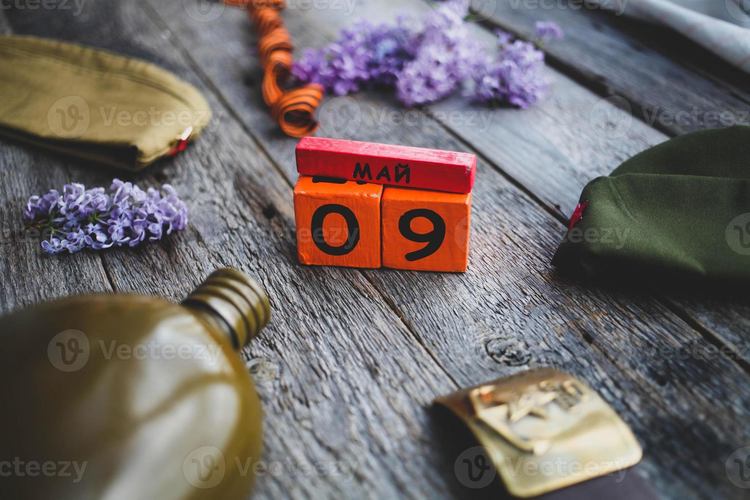 matraz, gorra , Jorge cinta y lila, soldado cinturón con un cinco puntas estrella con un martillo y hoz y un de madera calendario con el fecha texto en ruso mayo 9. victoria día. foto