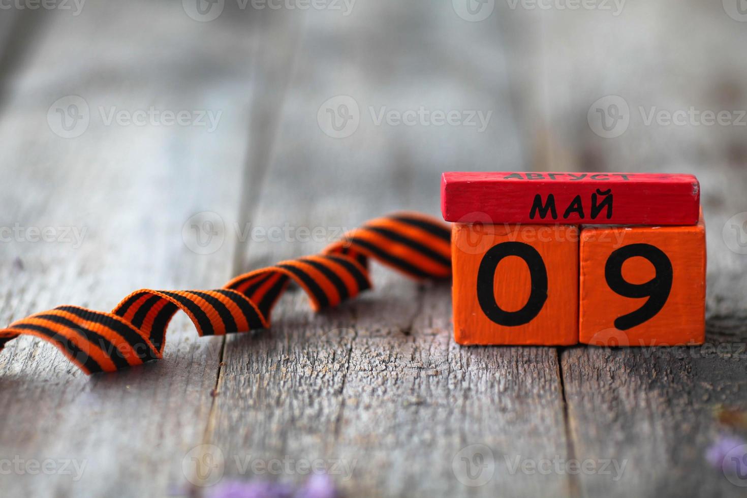 Wooden calendar with Russian text May 9 and  george ribbon  on a wooden background.  Copy space. photo