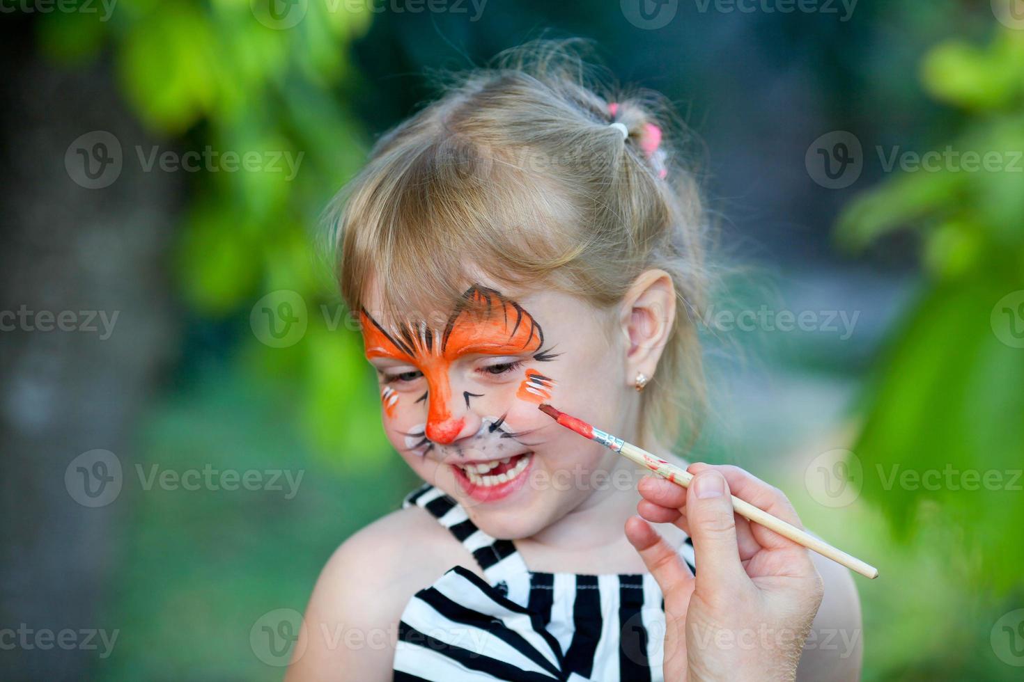 adorable niña consiguiendo su cara pintado foto