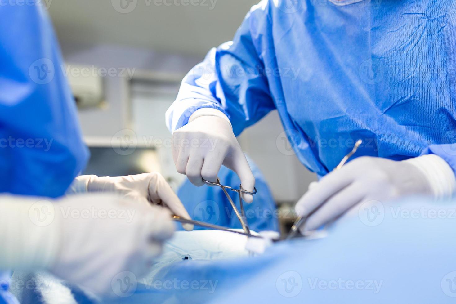 Operación quirúrgica. grupo de cirujanos en quirófano con equipo quirúrgico. antecedentes médicos, enfoque selectivo. equipo de cirujanos trabajando juntos durante la operación foto