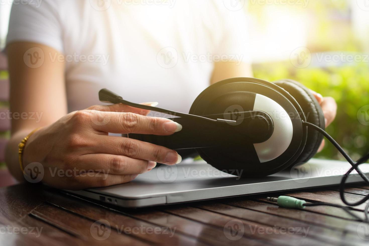 de cerca mano sostener auricular y computadora trabajo llamada centrar apoyo foto