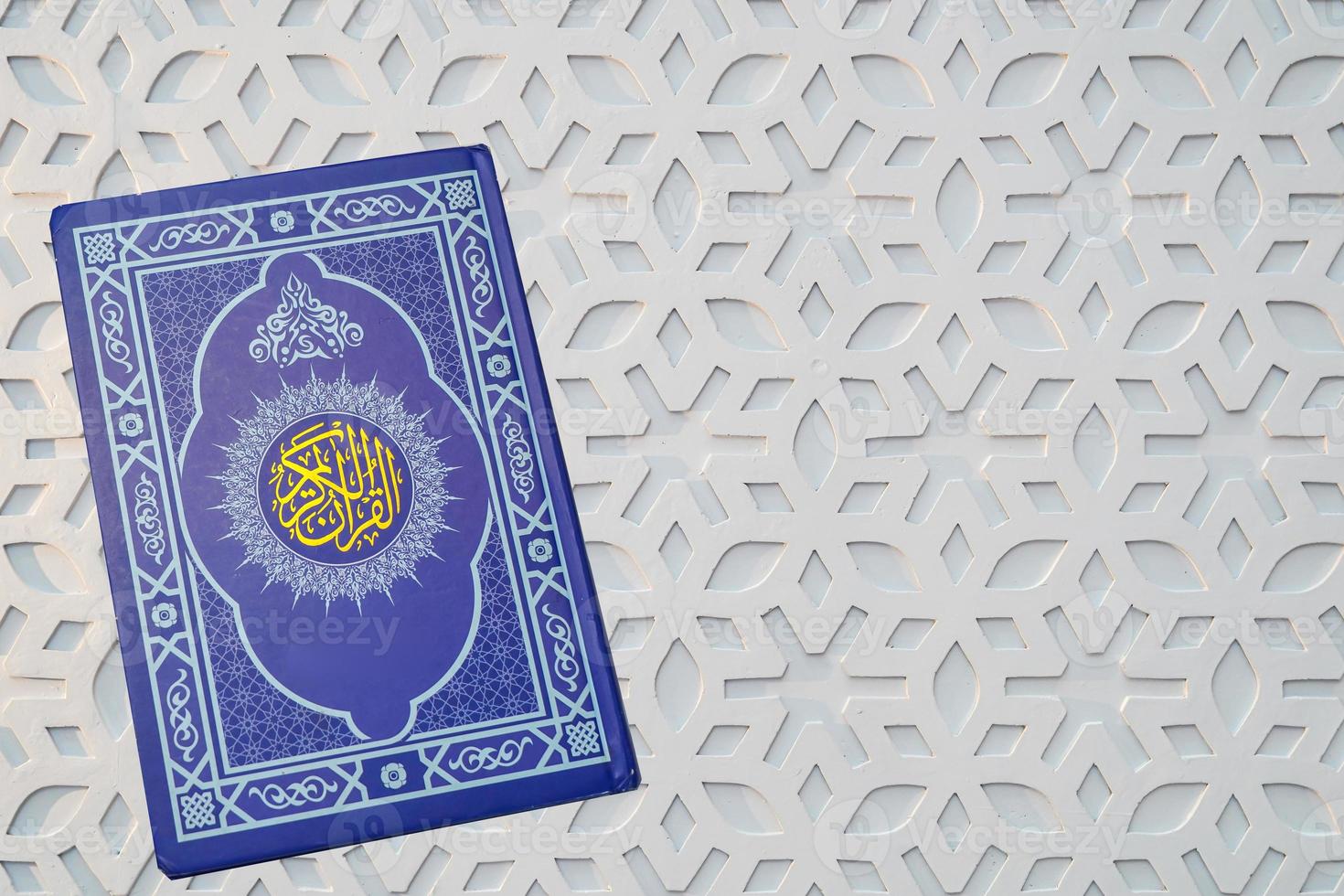 Holy Al Quran with written arabic calligraphy on white background with copy space photo
