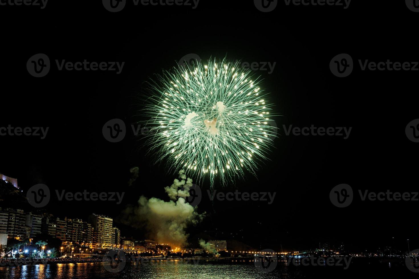 fuegos artificiales espectáculo a noche en el costas de el mar de alicante España foto