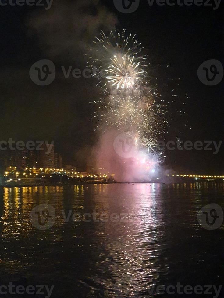 fireworks show at night on the shores of the sea of Alicante Spain photo