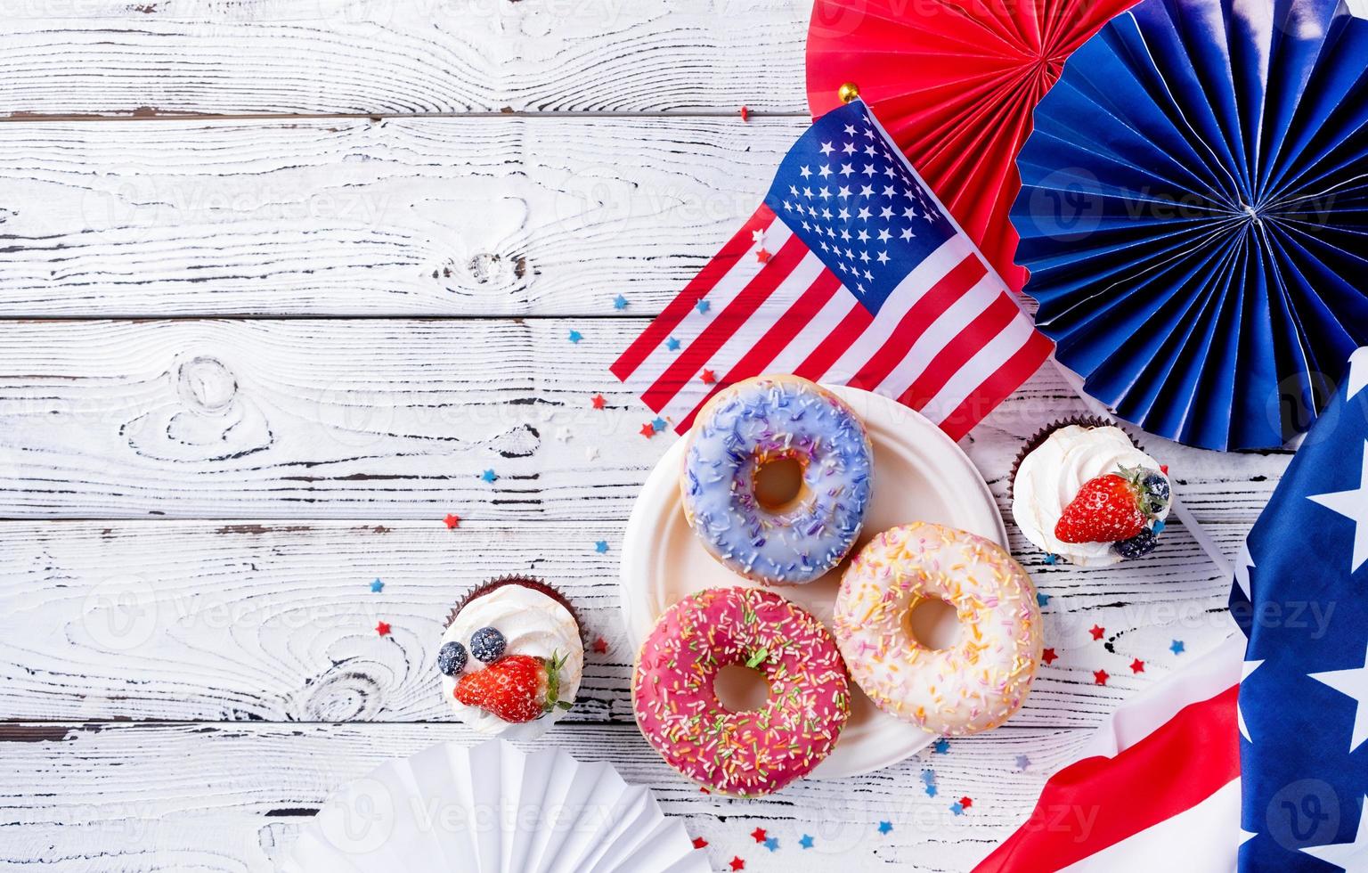 dulce magdalenas y rosquillas con Estados Unidos bandera en de madera antecedentes foto